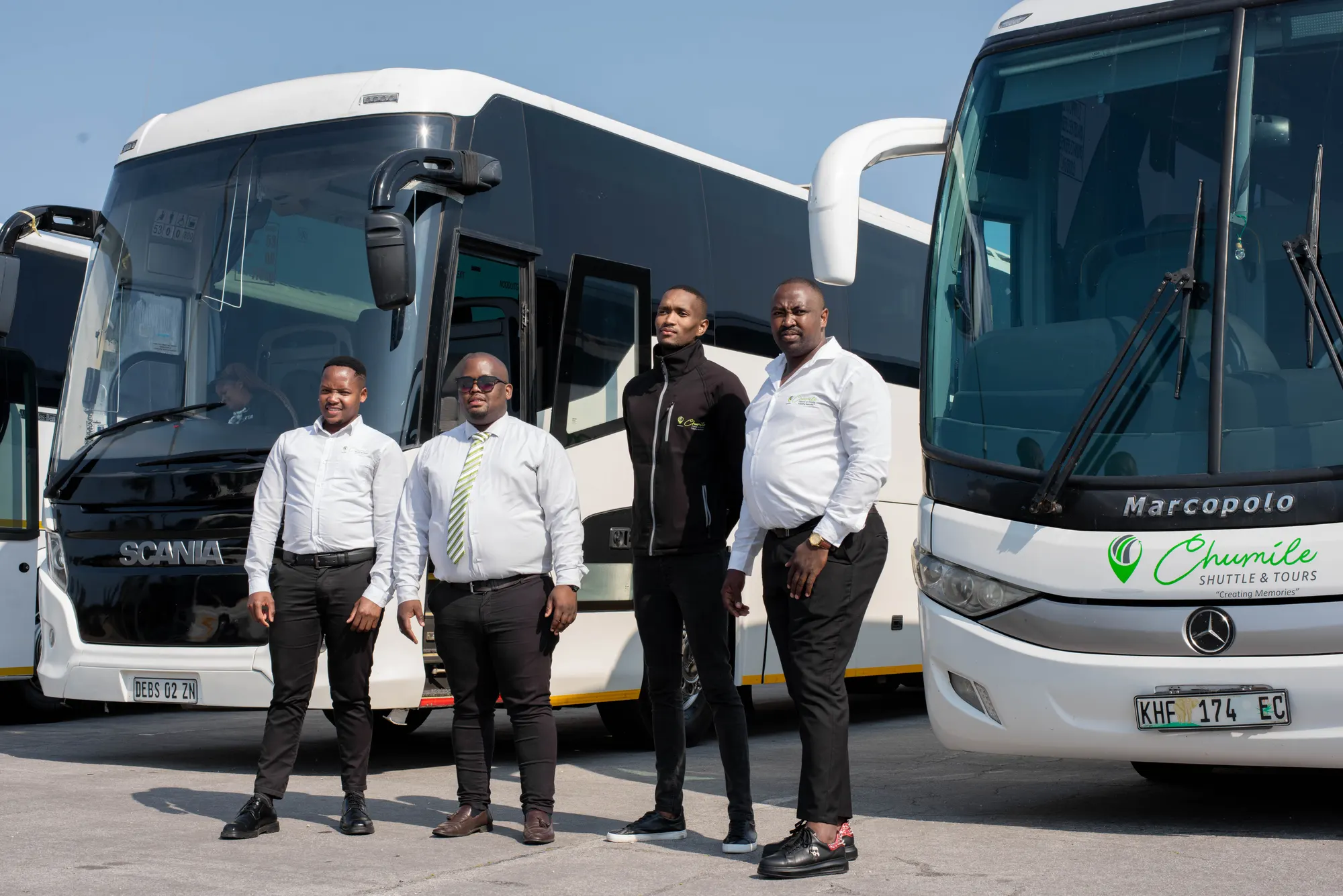 Chumile drivers in uniform standing in front of Scania and Marcopolo coaches