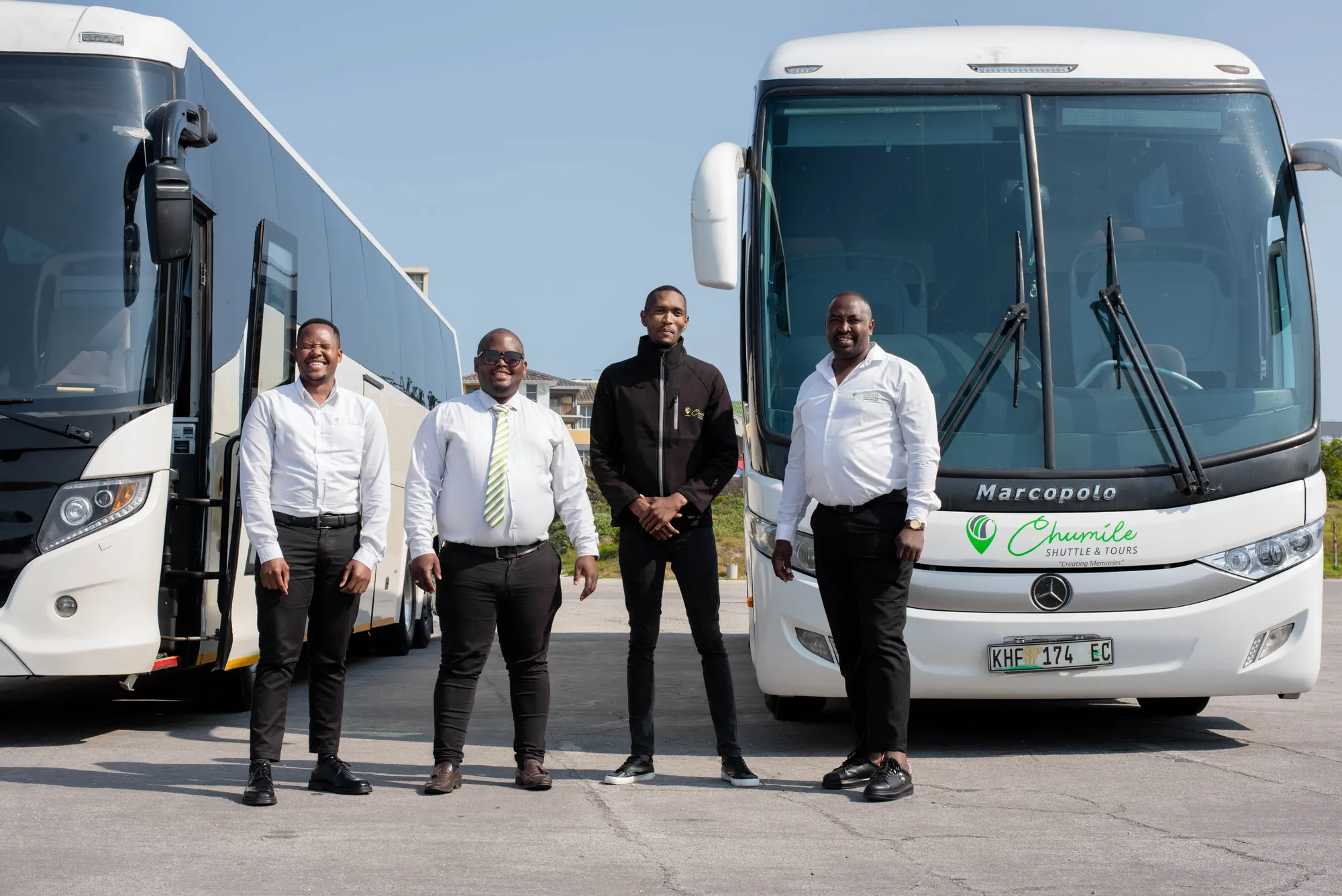 Four Chumile drivers in front of the coach fleet