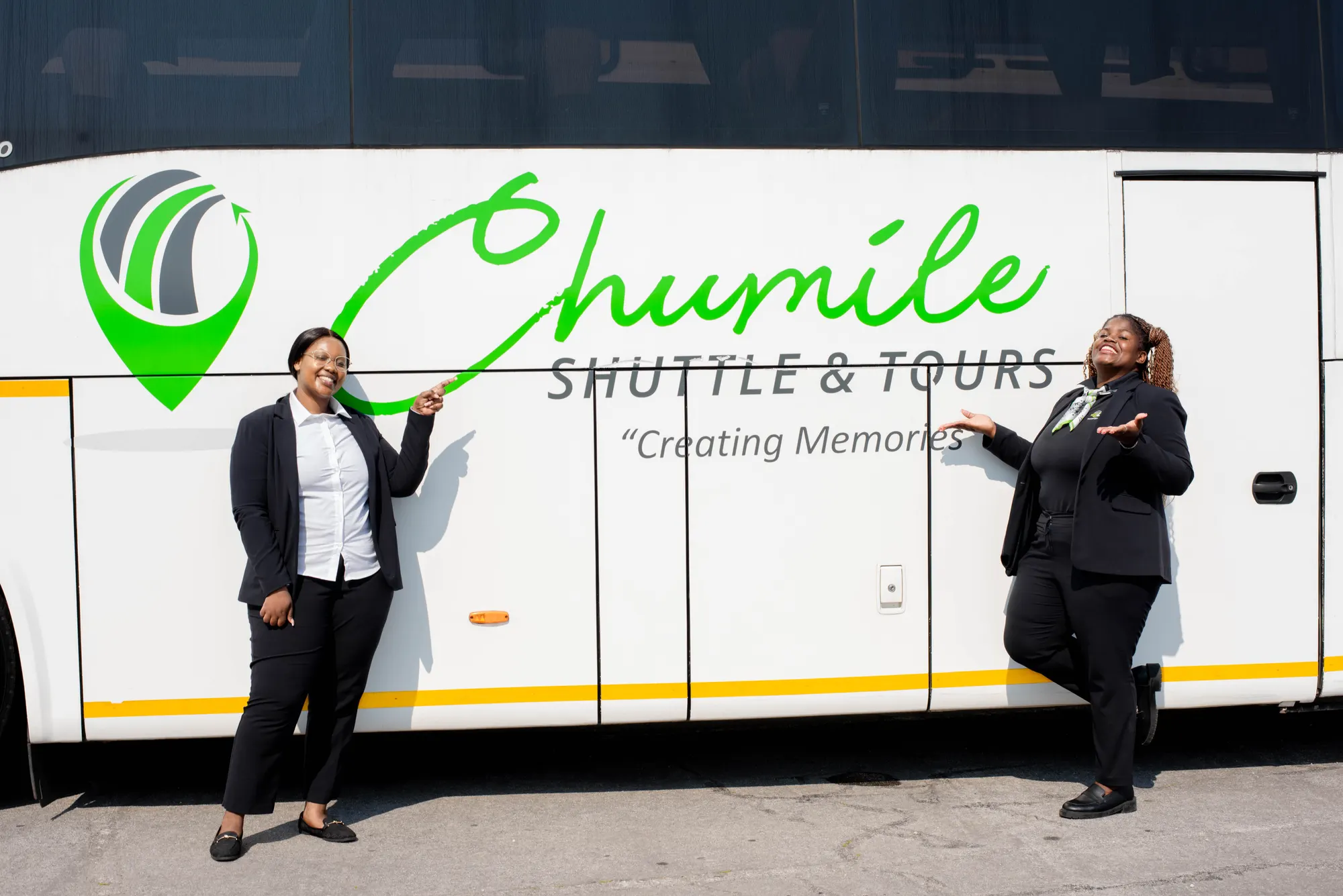 Two Chumile team members beside a branded Chumile coach